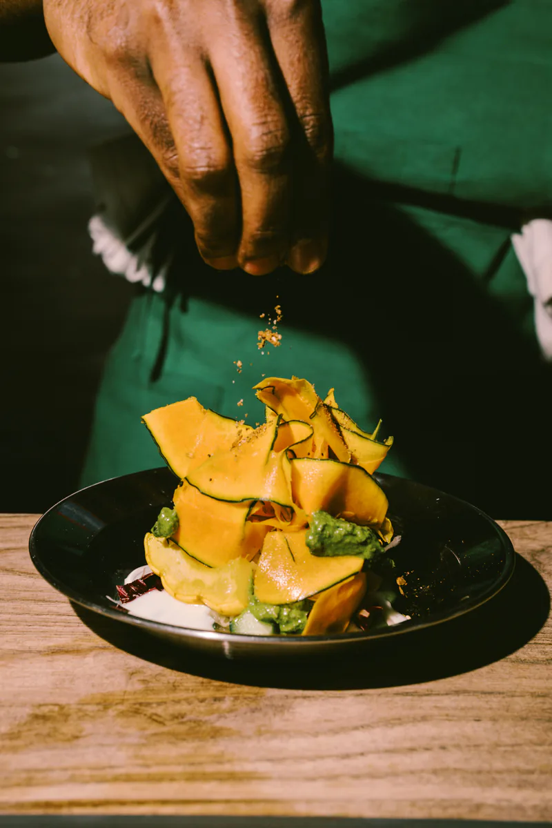 Chef en cuisine effectuant le dressage d'une assiette gastronomique
